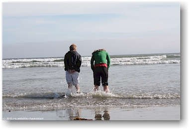 eine welle erwischt mathias und katrin bei der nrdlichen wickaninnish bay im pacific rim national park auf vancouver island