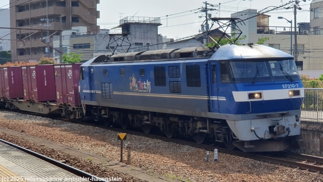 lokomotive an der spitze eines endlosen gueterzuges bei der durchfahrt im bahnhof onomichi