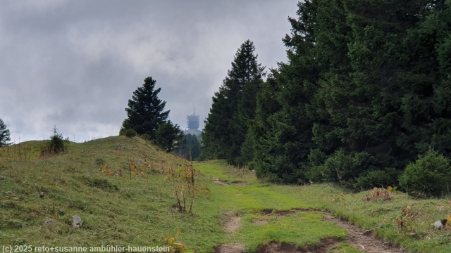 wolkenumhuellter turm auf dem gipfel waehrend dem aufstieg zum chasseral