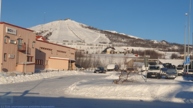 blick aus dem zug im bahnhof kiruna auf die skipisten am luossavaara